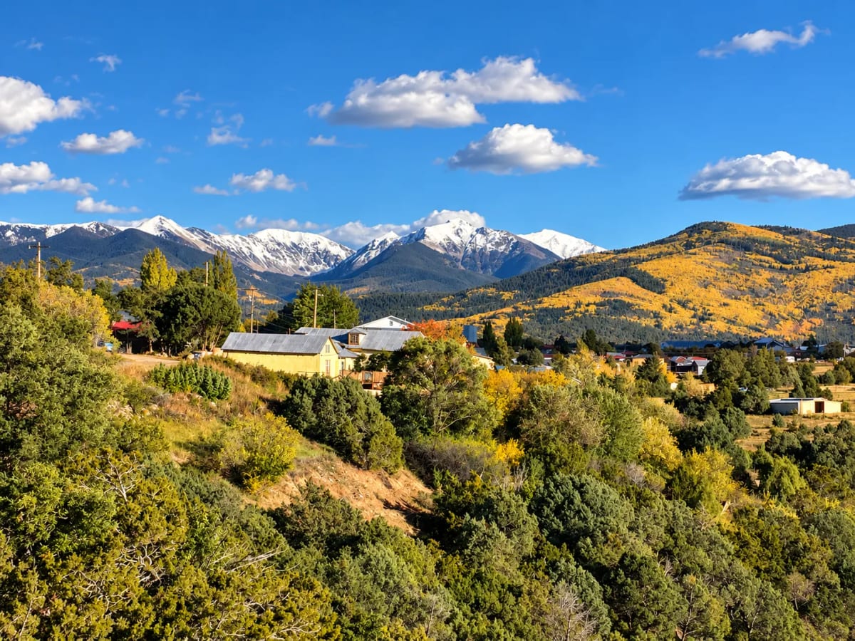 A village of tin-roofed houses below snow-capped peaks and slopes of golden aspen.